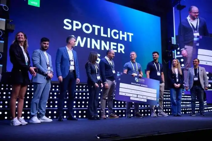 The LynxCraft team on stage with an oversized cheque under a screen reading Spotlight Winner