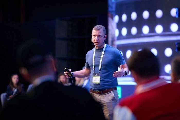 Pitching on stage with a headset microphone to the audience at the How to Web conference