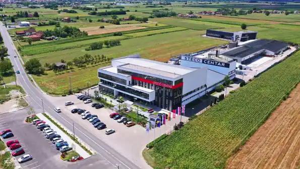 Poslovna stavba Steco Centar z zračnega posnetka, obdana s polji
